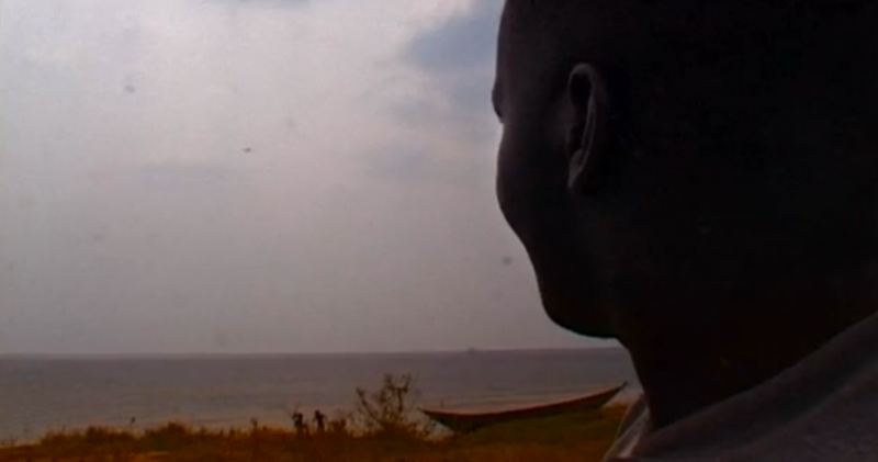 Figure 4 : un des personnages du film scrutant un avion survolant le lac et les barques des pêcheurs (capture d’écran)